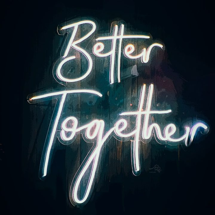 Leuchtender Schriftzug "Better Together" auf dunklem Hintergrund.